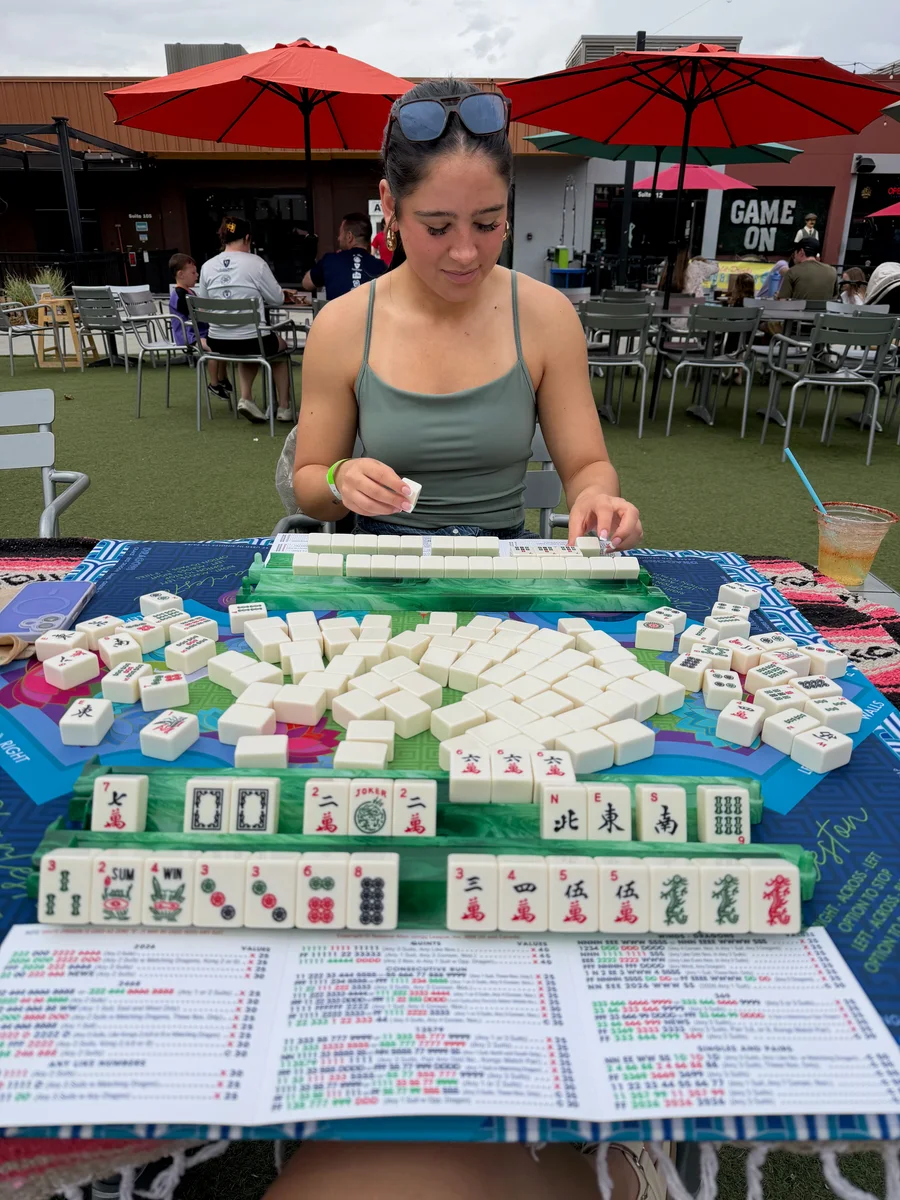 Maddy arranging tiles at an outdoor American Mahjong table in Fort Collins